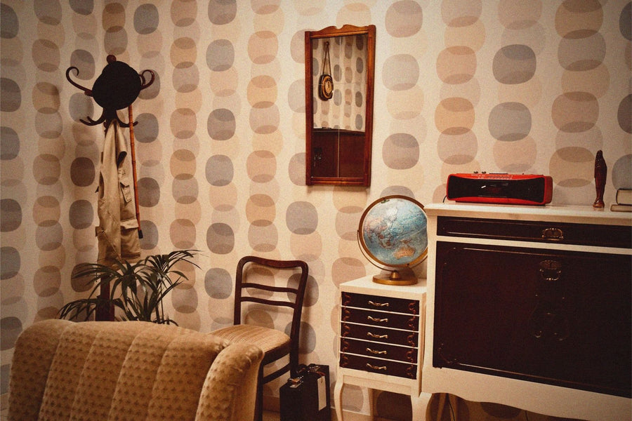 Retro-Wohnzimmer mit Mustertapete, Globus und Kommode im Raum Das Testament